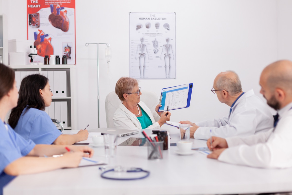 A care team meeting around a table, reviewing a chart
