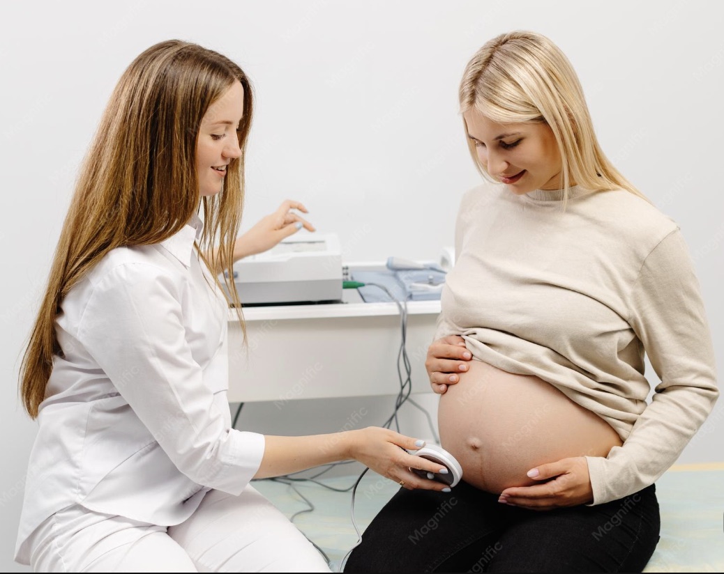 A clinician checks a pregnant woman's baby with a fetal heart monitor